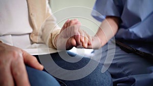 Close-up senior Asian woman hand with her caregiver helping hands, Caregiver visit at home. Home health care and nursing home