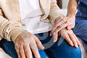 Close-up senior Asian woman hand with her caregiver helping hands, Caregiver visit at home. Home health care and nursing home