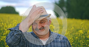 Close up of the senior Caucasian Looking at the camera good looking wise man farmer in a hat looking at the side