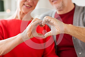 Close up of senior couple showing hand heart sign