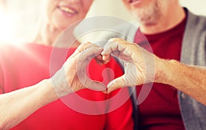 Close up of senior couple showing hand heart sign