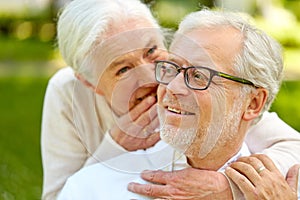 Close up of senior couple whispering outdoors