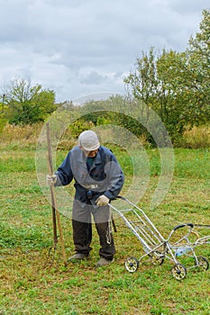 Close up of senior farmer using scythe to mow the lawn traditionally