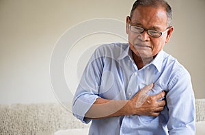 Close Up senior male asian suffering from bad pain in his chest heart attack at home. Healthcare and medical concept of senior