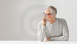 Close up of senior man in glasses thinking