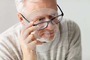 Close up of senior man in glasses thinking