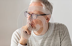 Close up of senior man in glasses thinking