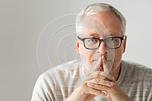 Close up of senior man in glasses thinking