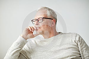 Close up of senior man in glasses thinking