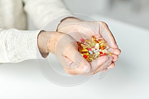 Close up of senior man hands holding pills