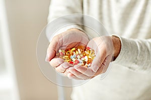 Close up of senior man hands holding pills