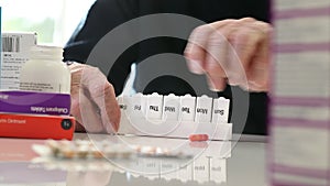 Close Up Of Senior Man Organizing Medication Into Pill Dispenser