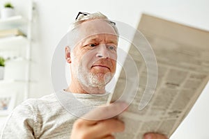 Close up of senior man reading newspaper at home