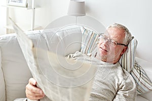 Close up of senior man reading newspaper at home