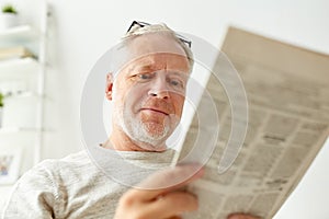 Close up of senior man reading newspaper at home