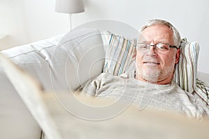 Close up of senior man reading newspaper at home