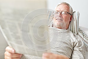 Close up of senior man reading newspaper at home