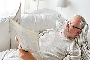 Close up of senior man reading newspaper at home