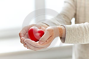 Close up of senior man with red heart in hands