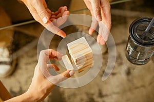 Close up of senior man`s hands doing his wooden constructor at home - concept of home studying