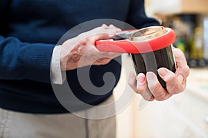 Close Up Of Senior Man Taking Lid Off Jar With Kitchen Aid