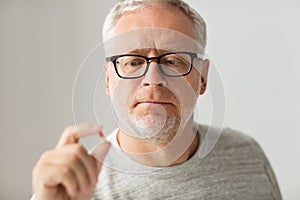 Close up of senior man taking medicine pill