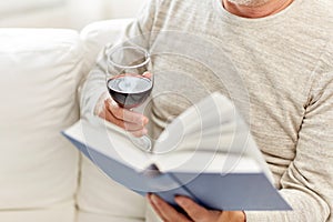 Close up of senior man with wine reading book