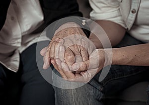 Close up of Senior mother and adult daughters hands holding each other