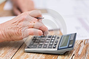 Close up of senior woman counting with calculator