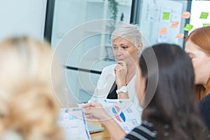 Close up senior woman listening to corporate meeting. business people meeting talking training company. brainstorming diverse