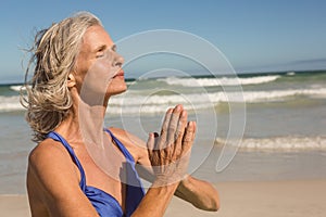 Close up of senior woman meditating at beach