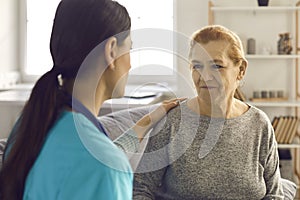 Close up of a senior woman receiving support from a young female nurse or doctor.