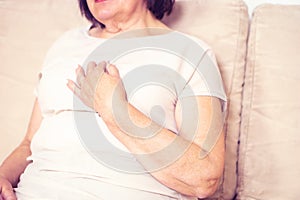 Close up of senior woman& x27;s hand holding her chest. Health problem, old age and people concept.