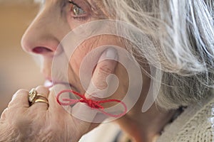 Close Up Of Senior Woman With String Tied Around Finger As Reminder