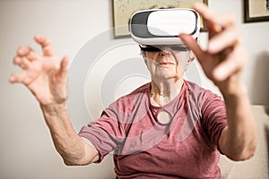 Close-up of a senior woman using virtual reality simulator in her home