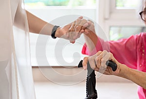Close up of senior woman and young woman holding hand ,people,age,family,care and support concept