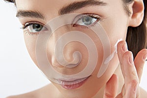 Close up sensual woman with cream on cheek