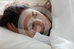 Close up serene beautiful woman sleeping under warm blanket alone