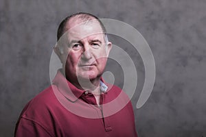 Close up of a serious mature man on a grey background