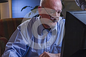 Close up of serious older man using home computer, horizontal