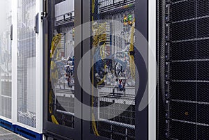 Close up server rack with LED indicator, internet wires, optic cables inside under meshed door photo