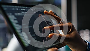 Close up of server room programmer checking coding on tablet