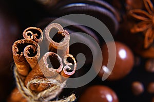 Close-up set of round crunchy chocolate cookies with coffee beans, sticks of cinnamon, anise star on a black background, macro, se