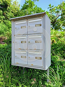 Close up of set of rusty mailboxes in natural environment of the French West Indies. Caribbean postal service. tropical culture