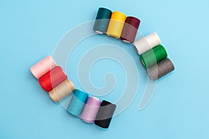 Close-up of several colored spools of sewing thread as a concept of different people in one common business