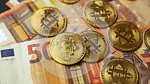 Close up of several gold bitcoin coins on 50 euro bills, camera panning movement. Bullish BTC, cryptocurrency, 2p2 exchange and