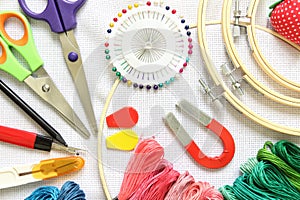 Close-up sewing and embroidery kit with threads and needle, button, scissors and fabrics on frame