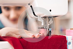 Close up of sewing machine. Girl at garment factory is sewing new dress.