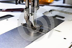 Close up of sewing machine needle with thread. Working part of antique sewing machine.