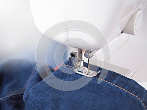 Close up sewing machine sew seam of blue denim jean